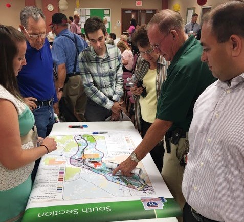 Participants in public scoping meeting looking at a project map.